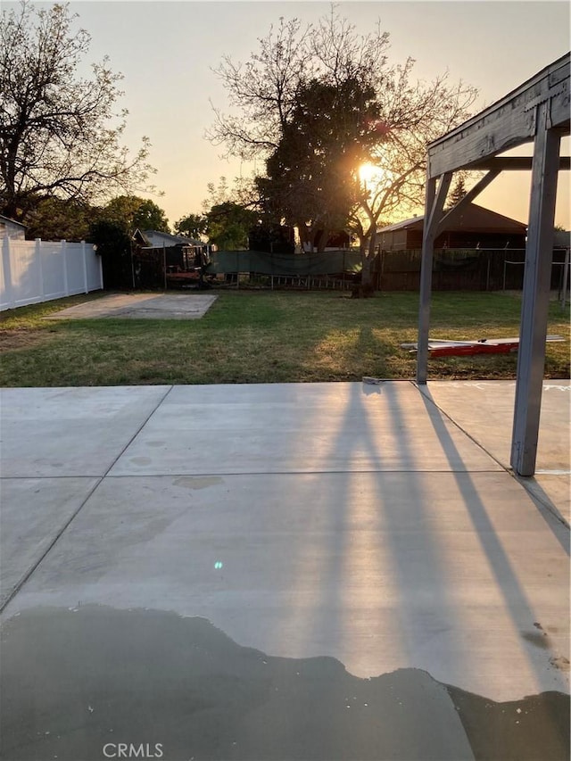 patio terrace at dusk with fence and a yard