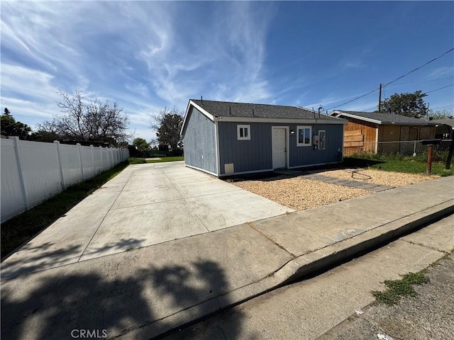 back of house featuring fence and an outdoor structure