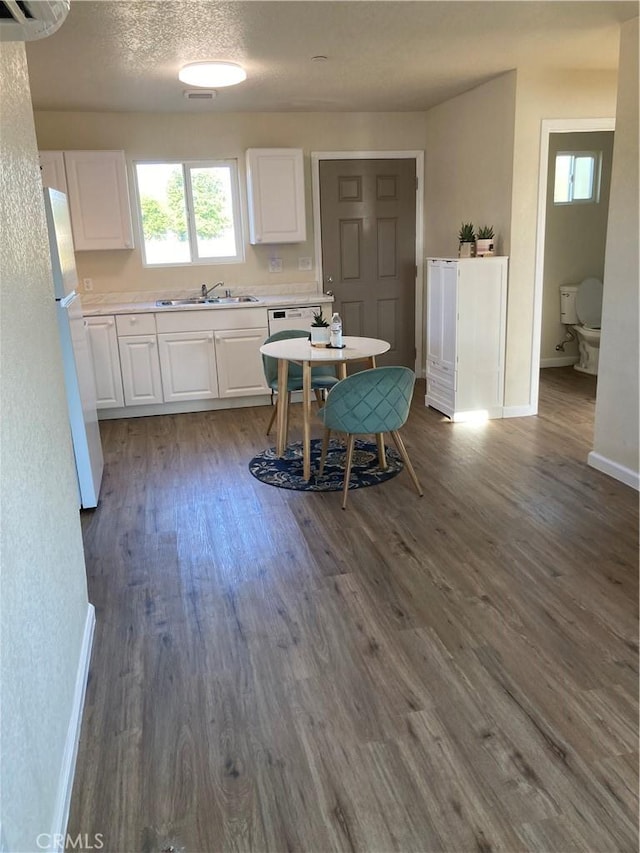 interior space with dark wood-type flooring, light countertops, and white cabinetry