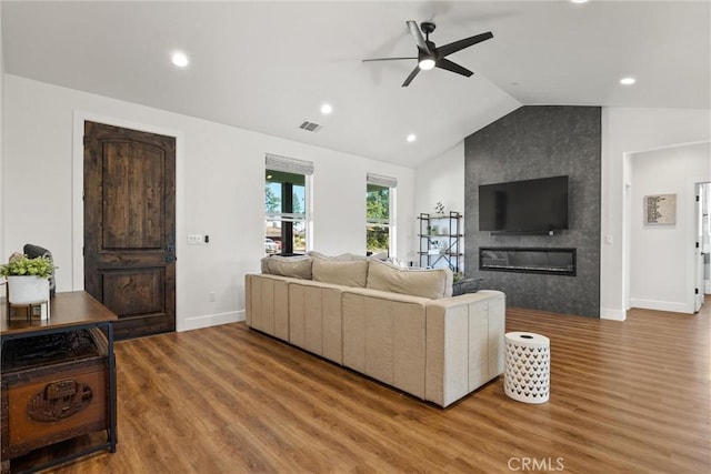 living area with wood finished floors, ceiling fan, baseboards, visible vents, and lofted ceiling
