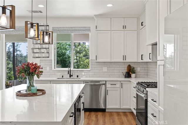 kitchen featuring tasteful backsplash, stainless steel appliances, recessed lighting, and a sink