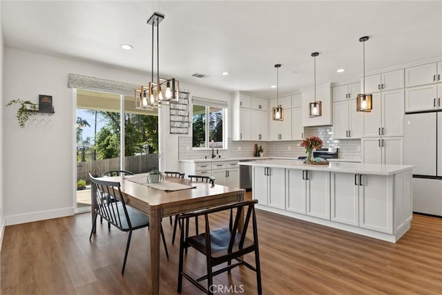 kitchen featuring white cabinetry, appliances with stainless steel finishes, visible vents, light countertops, and backsplash