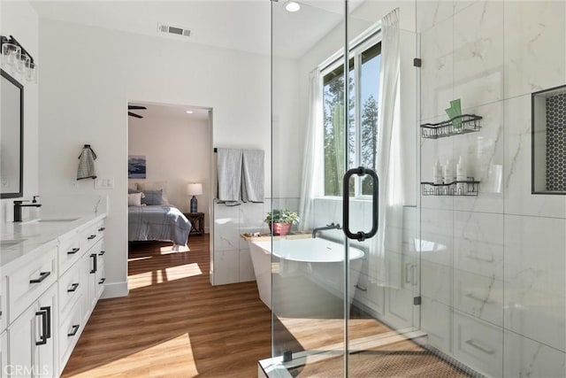 bathroom with a shower stall, wood finished floors, ensuite bath, visible vents, and a soaking tub