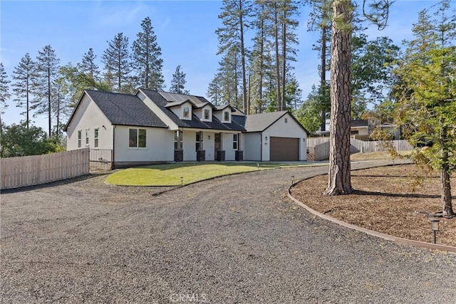 view of front of house featuring dirt driveway, stucco siding, roof with shingles, an attached garage, and fence