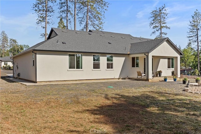 back of property with fence, a yard, a patio, and stucco siding