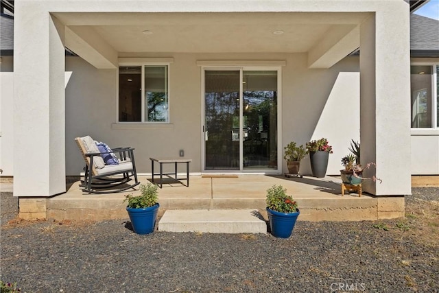 doorway to property featuring stucco siding and a patio area