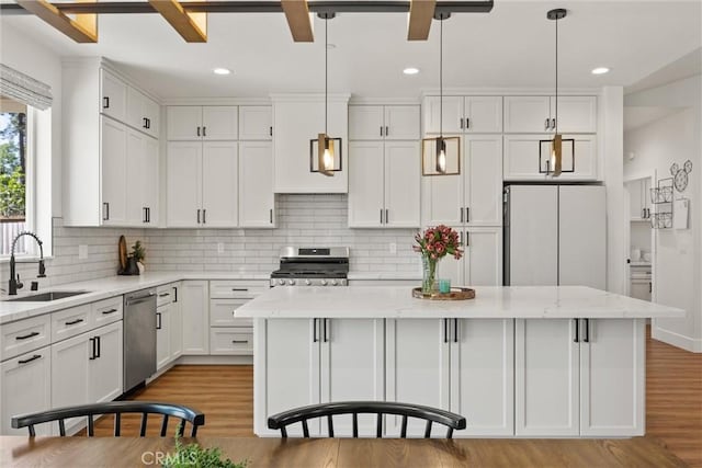 kitchen with a center island, stainless steel appliances, light wood-style floors, and a sink