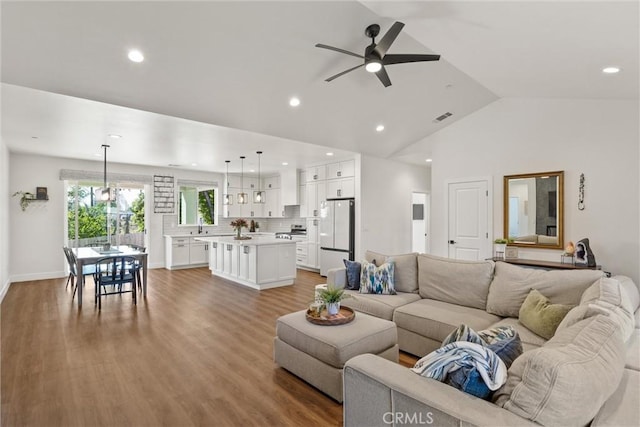 living room featuring lofted ceiling, visible vents, a ceiling fan, and recessed lighting