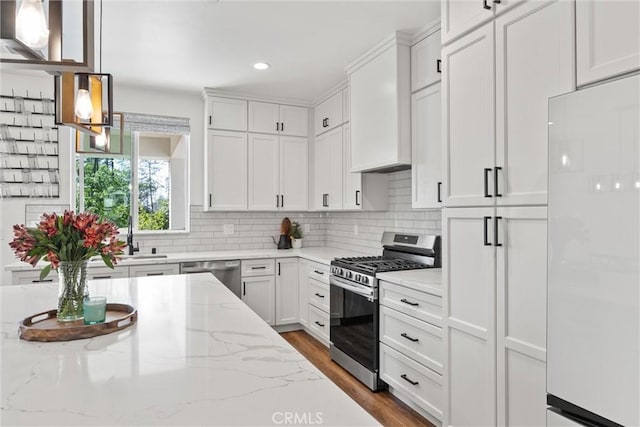 kitchen featuring dark wood-type flooring, stainless steel appliances, white cabinets, and backsplash