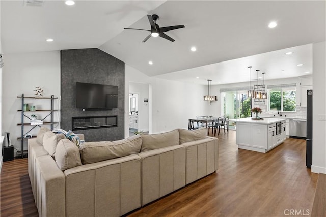 living room with recessed lighting, vaulted ceiling, a fireplace, wood finished floors, and a ceiling fan