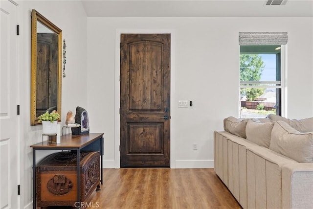 entryway with wood finished floors, visible vents, and baseboards
