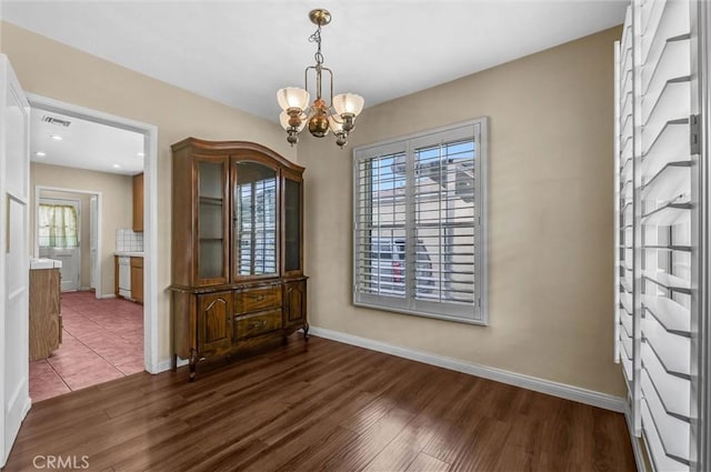 7518 Loch Alene Ave, Pico Rivera, CA 90660 - unfurnished dining area featuring an inviting chandelier, visible vents, dark wood-style floors, and baseboards