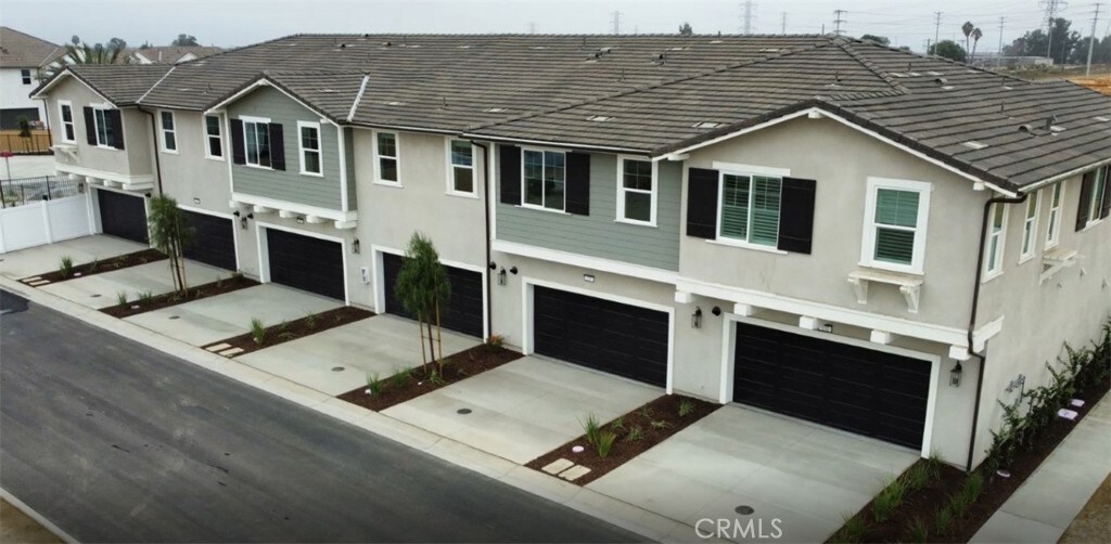 4016 E Lily Paseo Unit 120, Ontario, CA 91761 - view of front of home featuring a garage, stucco siding, and driveway