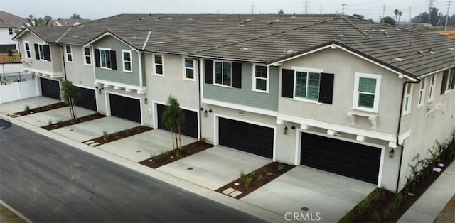 4016 E Lily Paseo Unit 120, Ontario, CA 91761 - view of front of home featuring a garage, stucco siding, and driveway