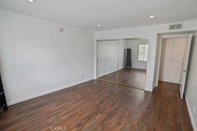 unfurnished bedroom with a closet, recessed lighting, wood finished floors, and visible vents