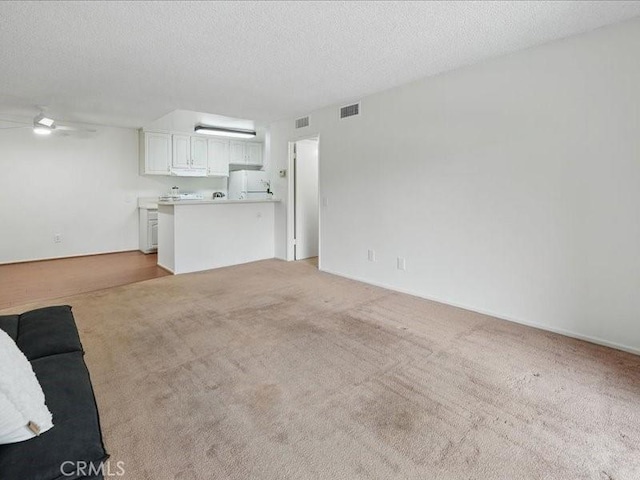 23515 Lyons Ave Unit 286, Valencia, CA 91355 - unfurnished living room featuring ceiling fan, light colored carpet, and a textured ceiling
