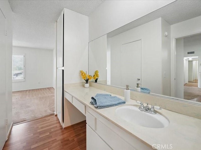 23515 Lyons Ave Unit 286, Valencia, CA 91355 - bathroom with a textured ceiling, wood finished floors, and vanity