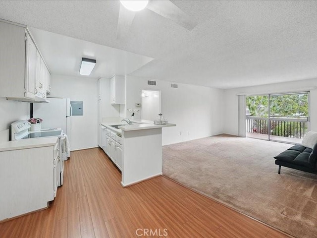 23515 Lyons Ave Unit 286, Valencia, CA 91355 - kitchen with stove, open floor plan, light countertops, a peninsula, and white cabinets
