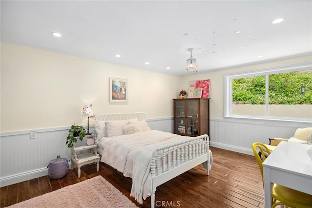 bedroom featuring recessed lighting, wainscoting, wood finished floors, and baseboards