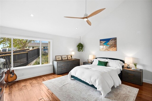 bedroom with a ceiling fan, high vaulted ceiling, wood finished floors, and baseboards