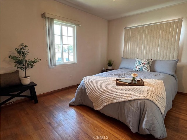 bedroom featuring baseboards and wood finished floors