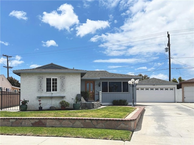 view of front of home with fence, a front yard, roof with shingles, stucco siding, and driveway