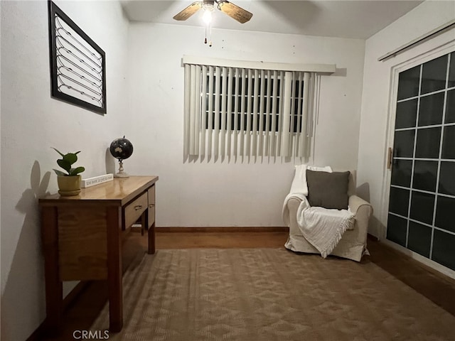 sitting room featuring a ceiling fan and baseboards