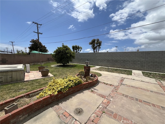 view of patio with a hot tub and a fenced backyard