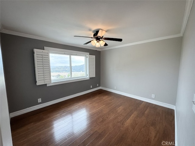 spare room featuring baseboards, ornamental molding, ceiling fan, and dark wood-style flooring