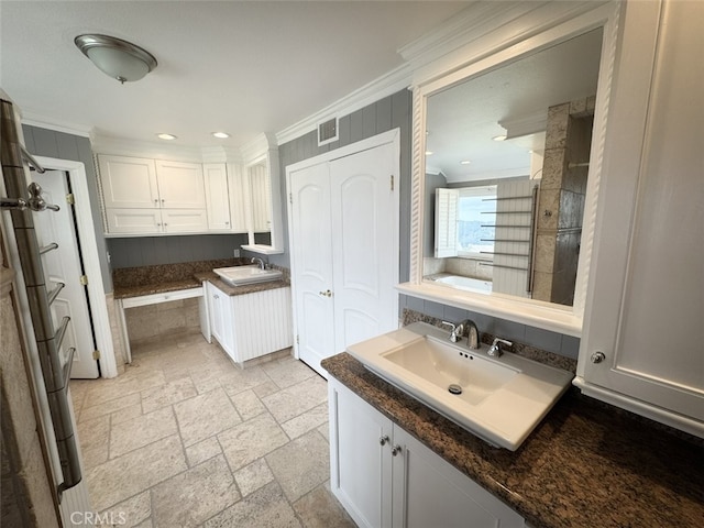 full bathroom with visible vents, stone tile flooring, crown molding, and a sink