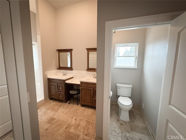 full bath with double vanity, toilet, decorative backsplash, and a sink