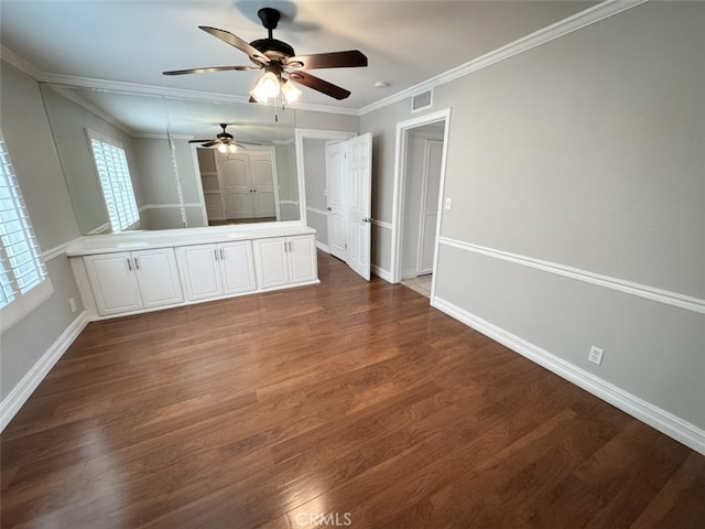 interior space with dark wood-style floors, ceiling fan, crown molding, visible vents, and baseboards