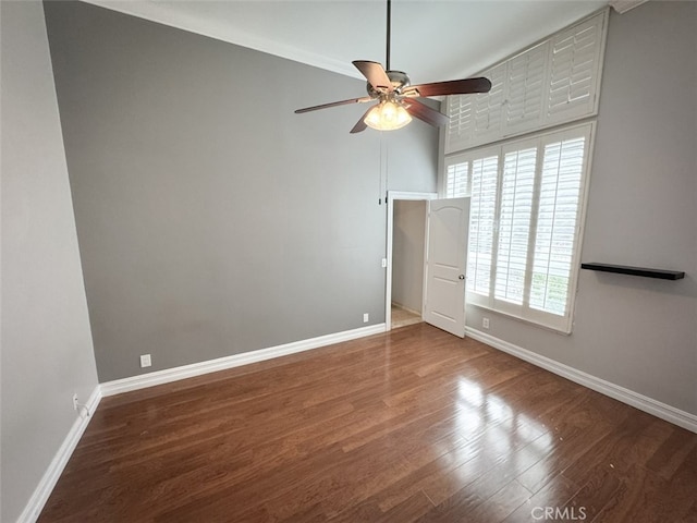 unfurnished bedroom with a ceiling fan, wood finished floors, and baseboards