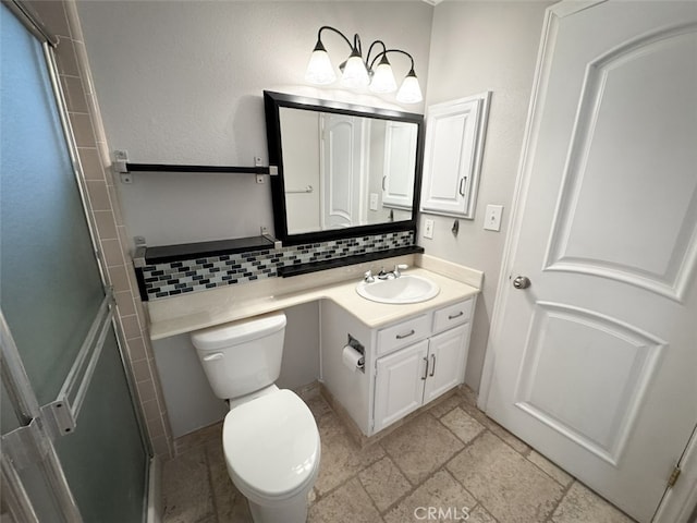 bathroom with decorative backsplash, stone tile flooring, a shower with door, toilet, and vanity