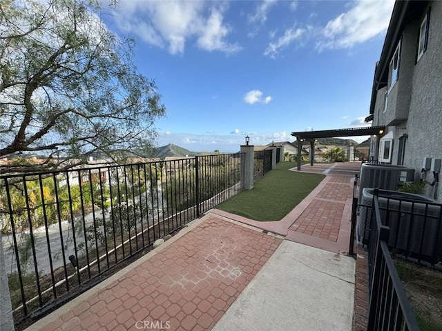 balcony with cooling unit, a mountain view, and a patio area