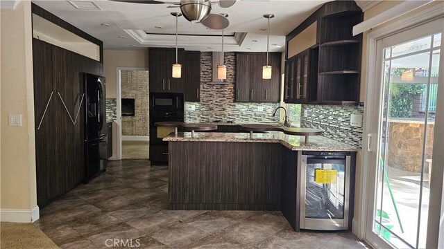 24722 Bracken Ln, Stevenson Ranch, CA 91381 - kitchen featuring dark brown cabinetry, a ceiling fan, black appliances, a peninsula, and beverage cooler