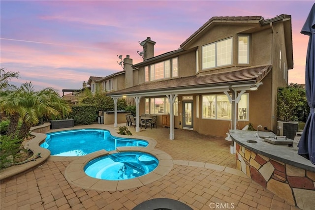 20704 Campania Ln, Porter Ranch, CA 91326 - rear view of house with a chimney, a patio area, stucco siding, central AC, and a pool with connected hot tub