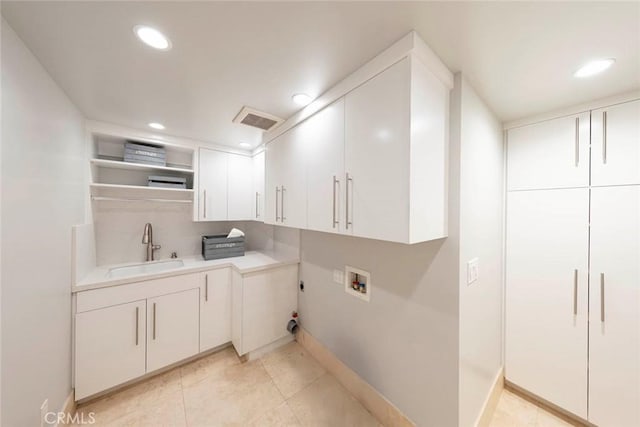 laundry room featuring hookup for an electric dryer, cabinet space, a sink, washer hookup, and visible vents