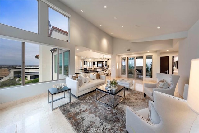 living area featuring tile patterned floors, recessed lighting, visible vents, and a towering ceiling