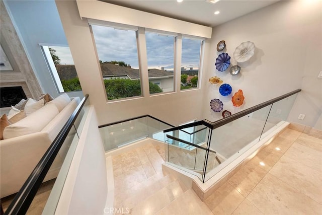 staircase with tile patterned floors, recessed lighting, and a large fireplace