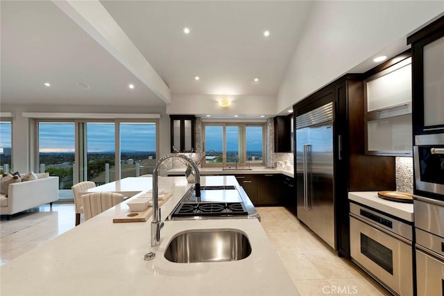 kitchen with light tile patterned floors, tasteful backsplash, appliances with stainless steel finishes, recessed lighting, and vaulted ceiling