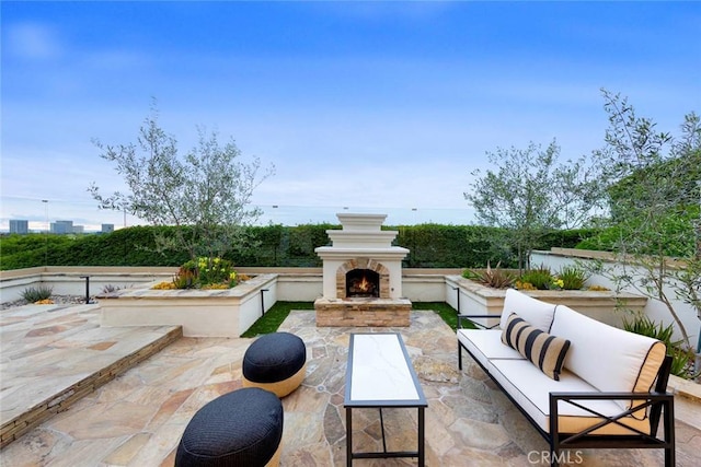 view of patio / terrace with an outdoor living space with a fireplace