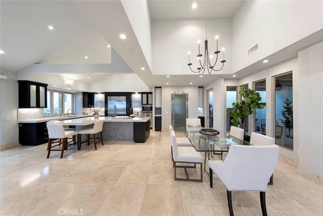 dining room featuring an inviting chandelier, visible vents, recessed lighting, and a high ceiling