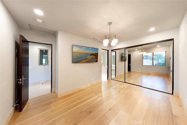 unfurnished bedroom with a chandelier, baseboards, a closet, recessed lighting, and light wood finished floors