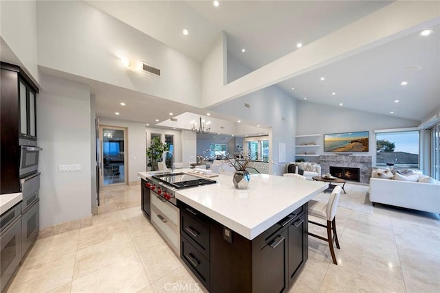 kitchen with a warm lit fireplace, recessed lighting, open floor plan, and light countertops
