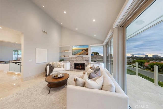 living room with visible vents, recessed lighting, a lit fireplace, and high vaulted ceiling
