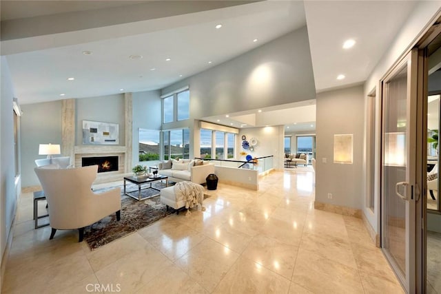 interior space featuring recessed lighting, a large fireplace, a high ceiling, and plenty of natural light