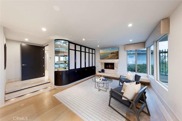 living room featuring baseboards, recessed lighting, wood finished floors, and a fireplace