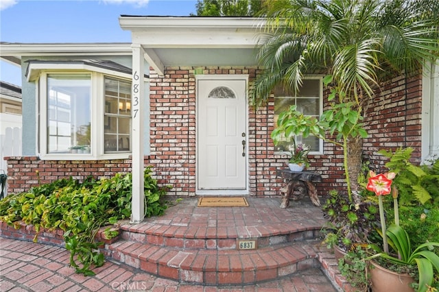 doorway to property with brick siding