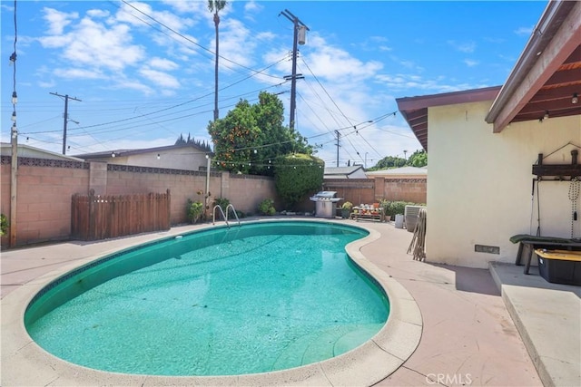 view of swimming pool with a fenced in pool, a fenced backyard, and a patio
